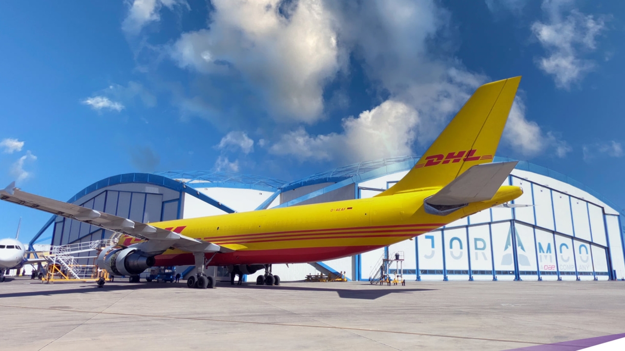 A DHL freighter parked outside Joramco hangars.